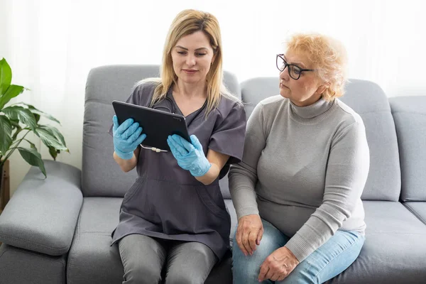 Γιατρός Νοσηλευτής Φροντιστής Κρατώντας Ένα Tablet Υπολογιστή Ηλικιωμένη Γυναίκα Στο — Φωτογραφία Αρχείου