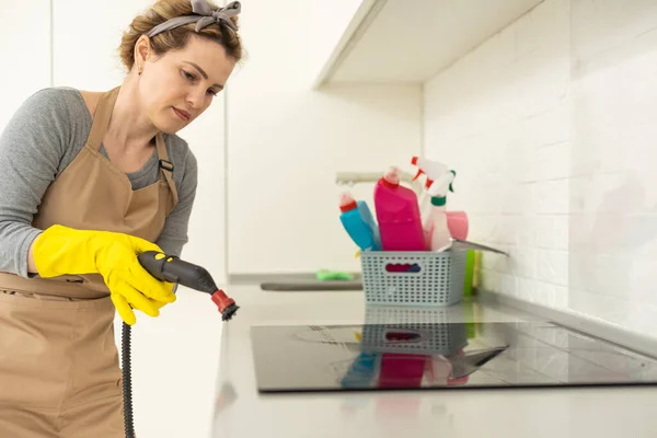 打扫房子 女孩用手套刷洗蒸汽清洁剂厨房白色电子寓言蒸汽 表面的清洁 轻便厨房 — 图库照片