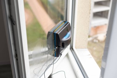 Camları temizleyen akıllı elektrik süpürgesi. Ev aletleri ve teknoloji konsepti.