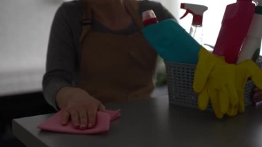 Evde bez ve dağıtıcı kullanan kadın masasını temizliyor