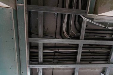 İşçiler asılmış tavanı alçıpanla birleştiriyorlar. Yüksek kalite fotoğraf