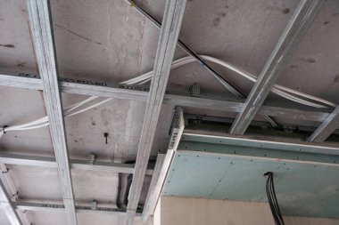 İnşaat aşamasındaki odada uzman teknisyenlerle tavan kurulumu. Yüksek kalite fotoğraf