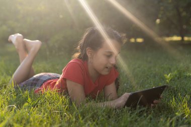 Eğitim, boş zaman, teknoloji ve internet konsepti - tabletli küçük kız öğrenci.
