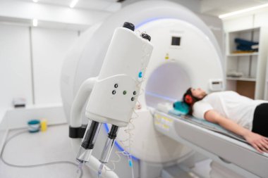 Modern hastane laboratuvarında bir hastaya tıbbi tomografi ya da MRI taraması yapın. Radyografi bölümünün içi. Beyaz odada teknolojik olarak gelişmiş ekipmanlar var. Manyetik rezonans tanılama makinesi.