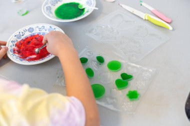 Çocuklar öğreniyor ve bilimsel deneyler yapıyorlar. Evde eğitim için bilim deneyi yapan küçük bir kız. Evdeki çocuklar için kolay ve eğlenceli bilimsel deneyler.