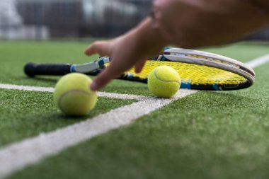 Tenis raketlerini ve tenis kortunda uzanan tenis toplarını kapatın. spor, tenis ve etkinlik