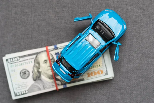 Money to buy or rent a car concept. Toy car with money cash.