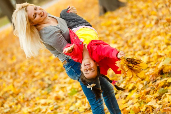 woman with daughter Outdoor having fun in autumn park.