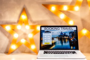 lights online booking and reservation. Search flights on a computer laptop screen, office desk background.