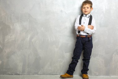 Elementary school student carrying notebooks over a gray background