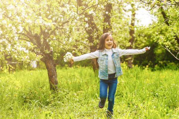 正在开花的苹果树旁的一个漂亮的小女孩的画像 — 图库照片