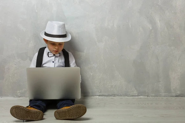 Kleine Jongen Met Laptop Tegen Grijze Muur Achtergrond — Stockfoto