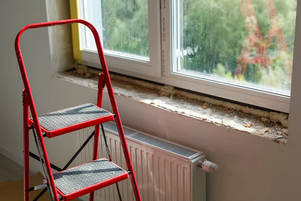 Installation of windows. Polyurethane foam on the slope of the window. Sealing window slopes