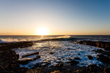 Denizde akşam sahnesi, taşlar, sakin okyanus.