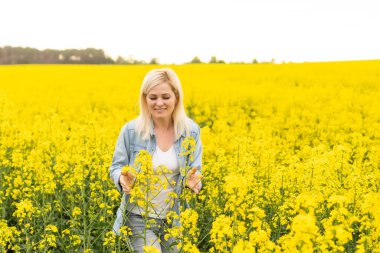 Çiçekli kolza tohumu çayırında güzel bir kadının portresi..