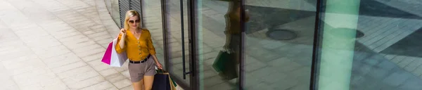 Vonzó Magabiztos Fiatal Áll Plázában Okostelefonnal Egy Csomó Bevásárlószatyorral Kezében — Stock Fotó