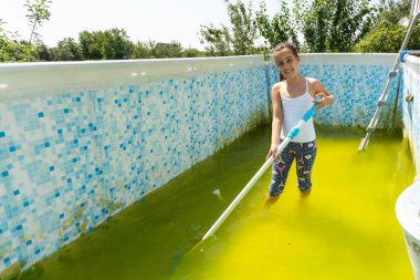 a little girl cleans a very dirty pool.