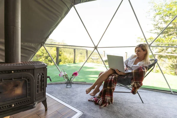 快乐的年轻女子在网上聊天使用笔记本电脑在穹顶露营 午休度假的概念 — 图库照片