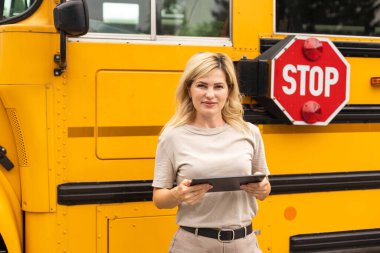 Portrait of female teacher near the school bus.