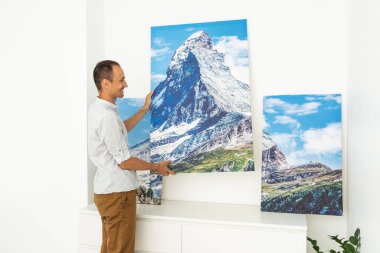 Modern Home Interior And Domestic Decor. a man is holding a photo canvas.