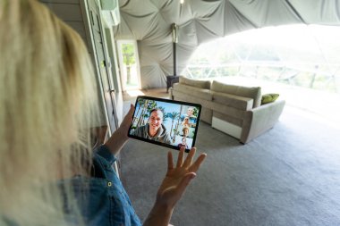 Tablet tutarak ve evde oturan genç kadın