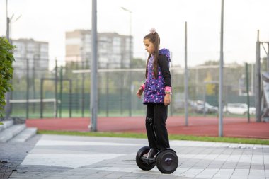 Küçük kız Segway 'e biniyor ve hafta sonu eğleniyor.