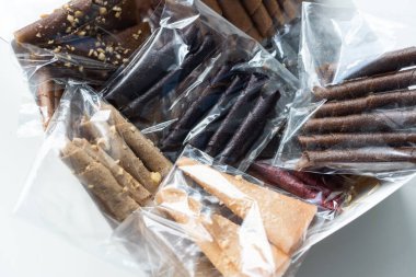 El yapımı el yapımı pastil kutuda ve tüm meyve, ceviz ve tarçınlı çubuklar hafif arka planda. Farklı meyve ezmesi, çilek, siyah frenk üzümü, mango. Sağlıklı atıştırma konsepti