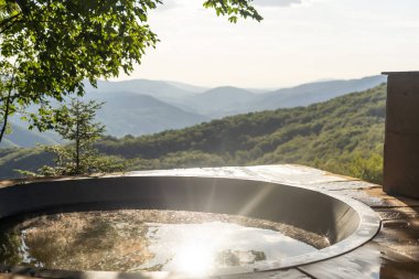 Dağlardaki terasta tahta sıcak fıçı. Sıcak banyolu tatil konsepti. yaz.