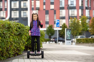 Küçük kız Segway 'e biniyor ve hafta sonu eğleniyor.