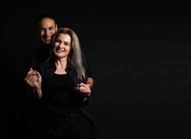 Adam, gri arka planda güzel kadına sarılıyor.