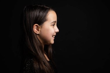 Bir çocuğun portresi. Siyah arka planda küçük bir kız..