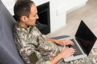 Genç askeri asker adam dikey, arka plan üstünde laptop