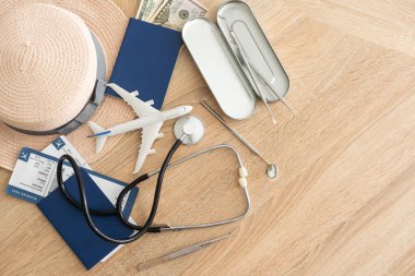 Medical Tourism, medical travel concept. Stethoscope, toy plane and passport on wooden background.