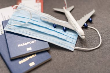 Corona virüsü maskesi nedeniyle COVID-19 seyahat kısıtlaması. Havaalanında ve Avrupa 'ya uçak seferlerinde zorunlu takılıyor. Pasaport, bilet ve tatil için hazır.
