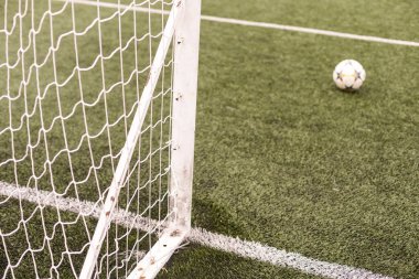 Parktaki yeşil çimlerin üzerinde futbol ya da futbol kale direği. Hiç kimse. Sakin ol. Spor temalı arka plan. Açık hava aktivitesi için eğitim sahası.