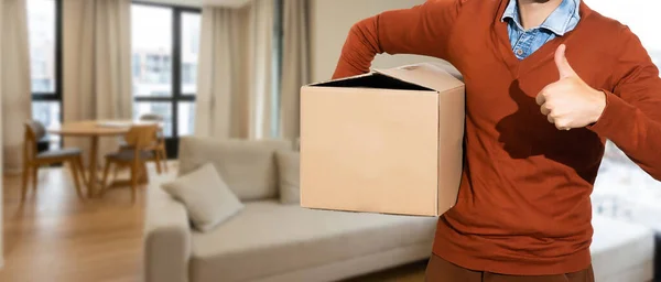 一个热情洋溢的年轻人提着纸板箱 搬出家门 — 图库照片