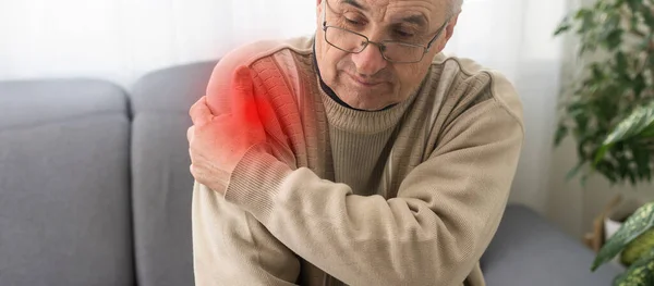 男人手牵着疼痛的肩膀 红点指示位置 — 图库照片