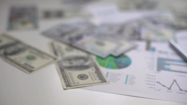 İşletme grafiği kağıt kalem hesap makinesi ofis masasında bir dolar. Mali raporlar kontrol ediliyor