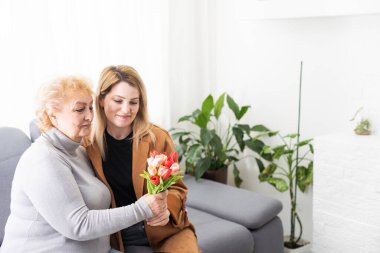 Genç bir kadın ve anne evde birlikte vakit geçiriyorlar.