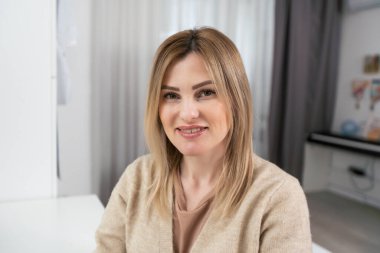 Ofiste dizüstü bilgisayarla çalışırken gülümseyen güzel bir kadın resmi.