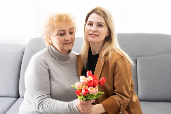 Glad Mödradag Vacker Ung Kvinna Och Hennes Mor Med Blommor — Stockfoto