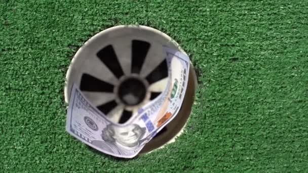 ゴルフ場の穴にお金の山 マネーショットコンセプト — ストック動画