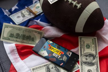 smartphone, money and rugby ball on light background. Concept of sports bet.