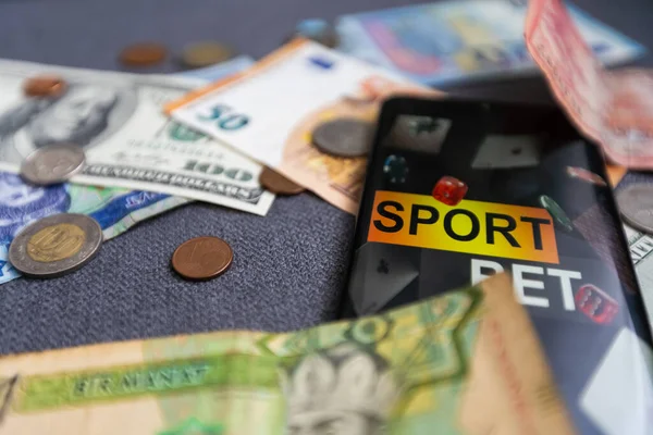 dollars and euros, smartphone with sports bet application.