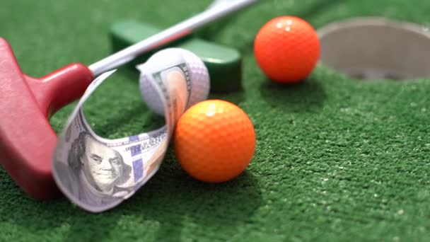 ミニゴルフクラブ 人工芝のボールとお金 — ストック動画