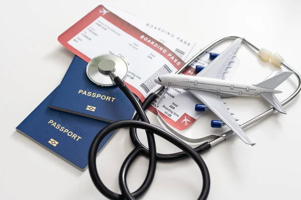 听诊器 白色背景的玩具飞机 旅行途中的健康保险 — 图库照片