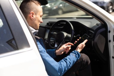 Mutlu heyecanlı milenyum adamı akıllı telefon ekranına bakıyor.