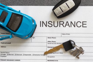 Araba sigortası formu, araba anahtarı ve oyuncak araba..