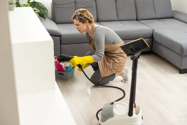 Mujer limpieza de sofá con aspiradora en casa. concepto de