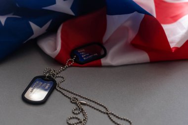Arka planda Amerikan bayrağı ve asker künyesi. Gaziler Günü Konsepti